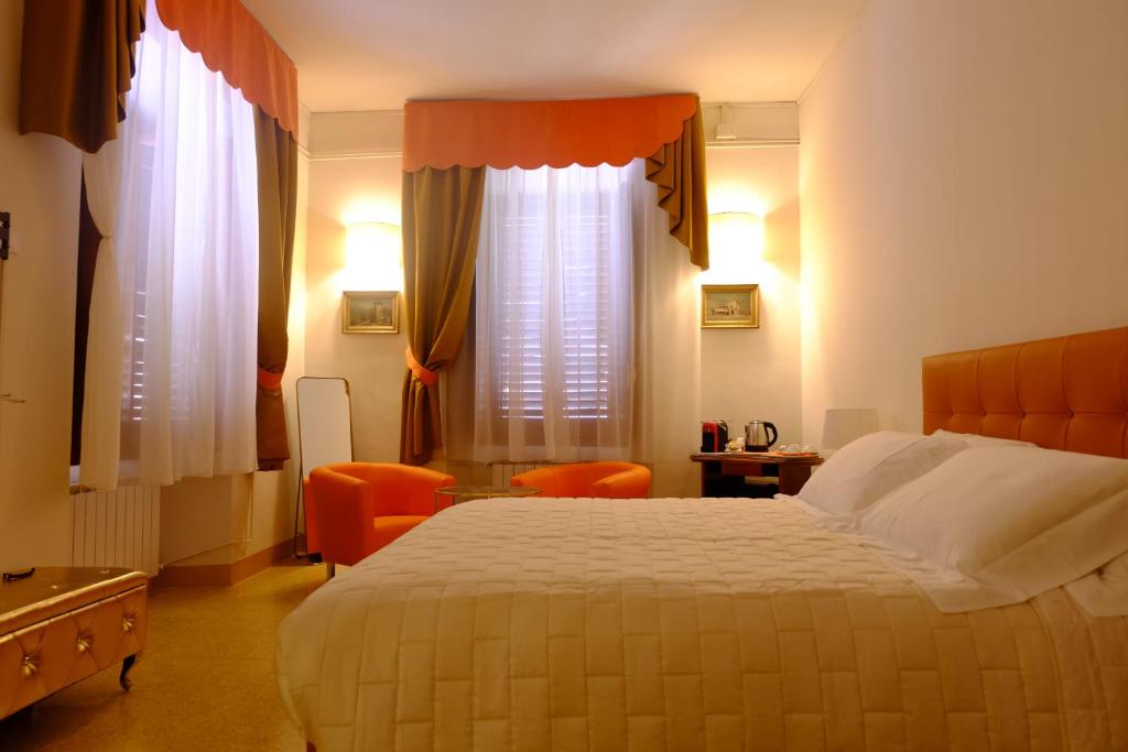 斯坎诺Bed & Breakfast Costanza4的酒店客房设有一张床和两个窗户。