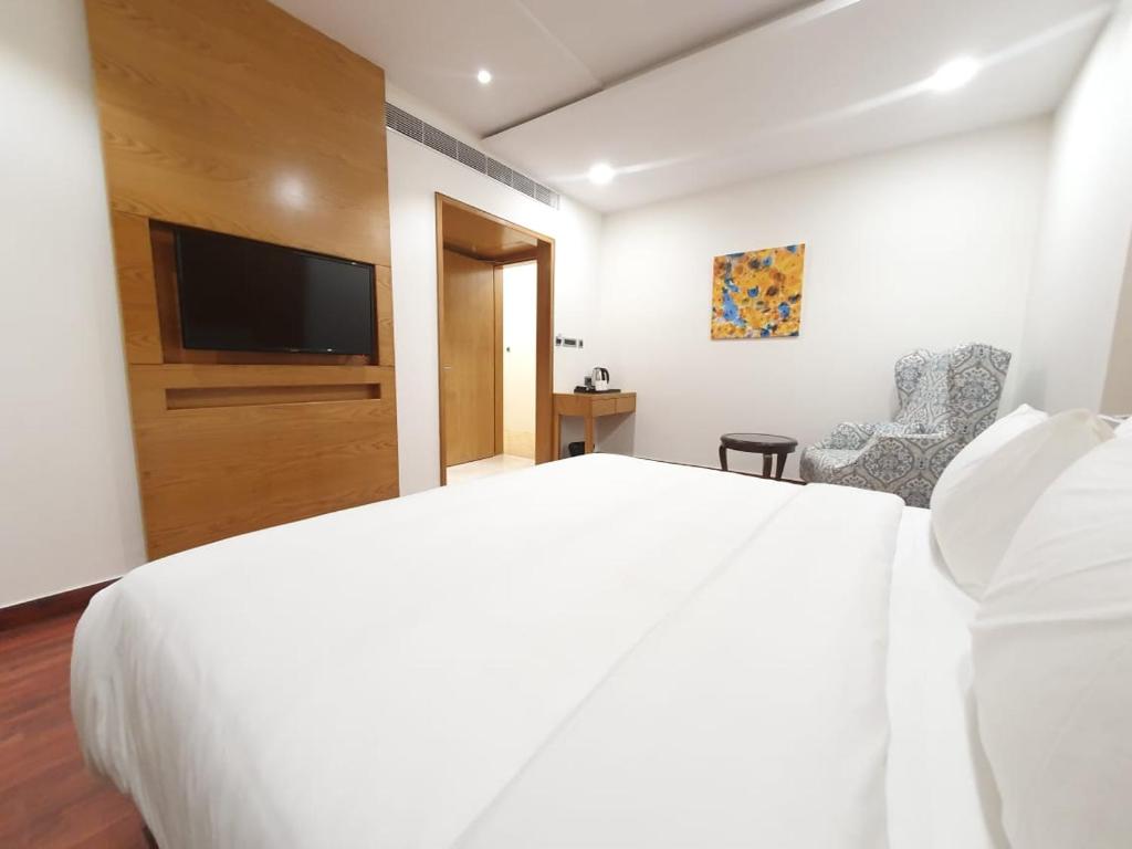 瓜廖尔The Moziac Hotel的卧室配有白色的床和平面电视。