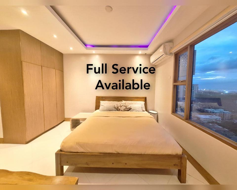 马尼拉Manila BayView Rental- Luxury 1,2,3,4 BR Condos with BALCONY POOL BAYVIEW - FULL SERVICE AVAILABLE的卧室配有墙上的全套服务标志