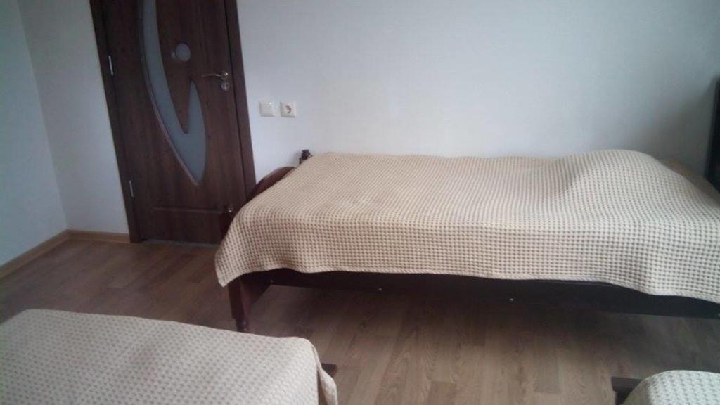 巴统Guest House Batumi的一间卧室设有两张床,铺有木地板