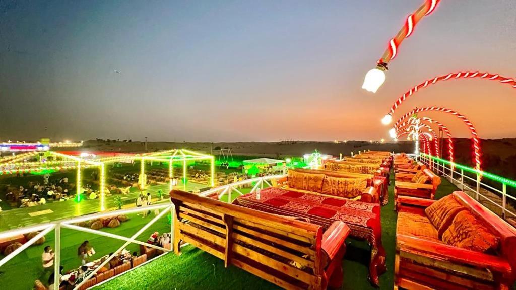 迪拜Overnight Chalet Campsite best for Couples Friends Parties and Overnight Event的一组长椅,坐在田野顶部