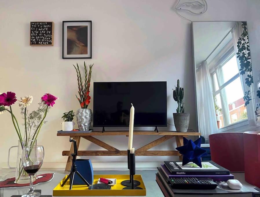 阿姆斯特丹Lovely, light and calm 1-bedroom apartment的客厅设有一张桌子和一台电视