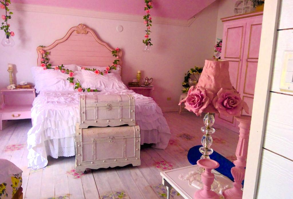 拿骚Its Day One I Do Bridal Dressing Suite的粉红色的卧室,床上有玫瑰花床