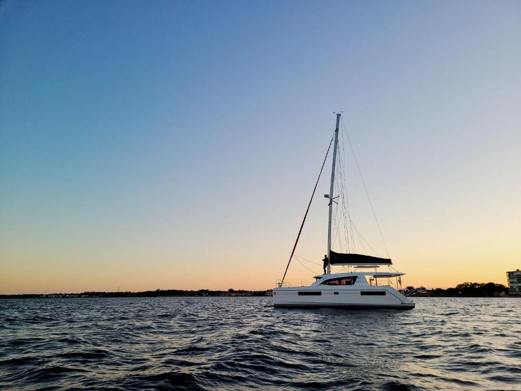 圣徒皮特海滩Florida Sail的日落时分在水面上的一艘白色帆船