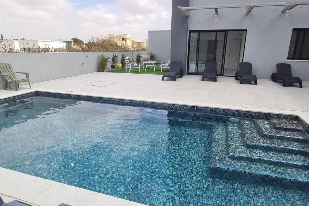 特拉维夫Luxurious Villa at the country side!的一座房子前面的蓝色海水游泳池