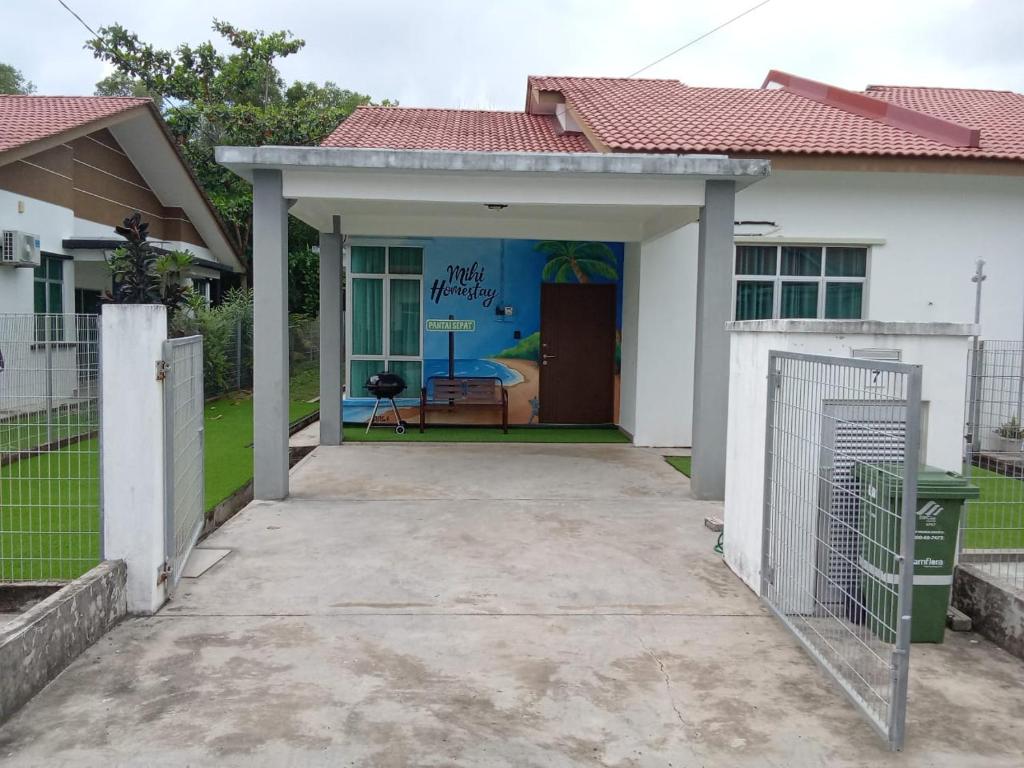 关丹MIHI Homestay Pantai Sepat的白色的房子,有车库和车道