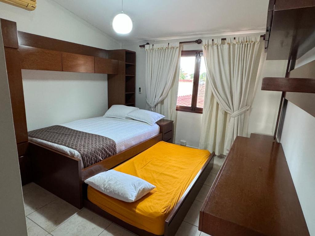 圣克鲁斯Hermosa casa amplia en zona residencial的一间小卧室,配有两张床和窗户