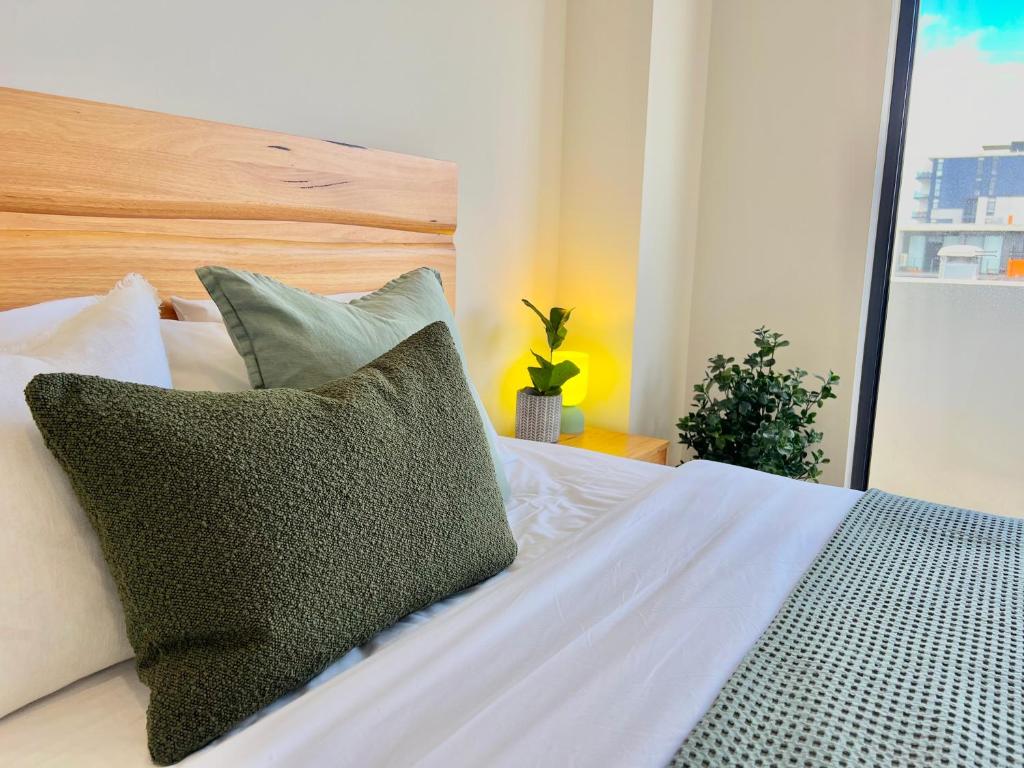 纽卡斯尔Harbour Towers, Newcastle's Luxe Apartment Stays, Free Parking的一张带绿色和白色枕头的床