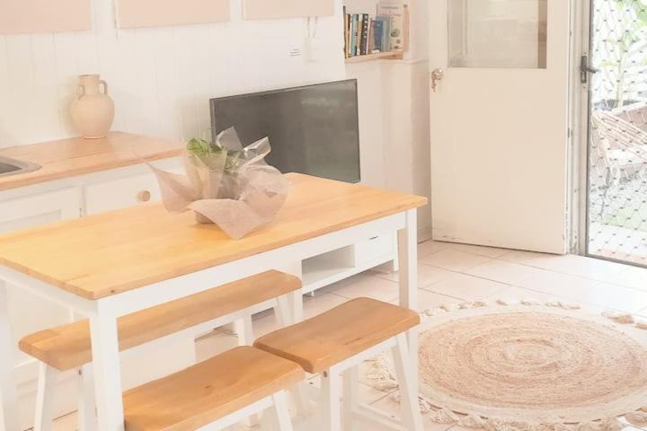 黄金海岸Entire Guest Suite - Close to Beach - Pets Welcome的白色的厨房配有桌子和电视。