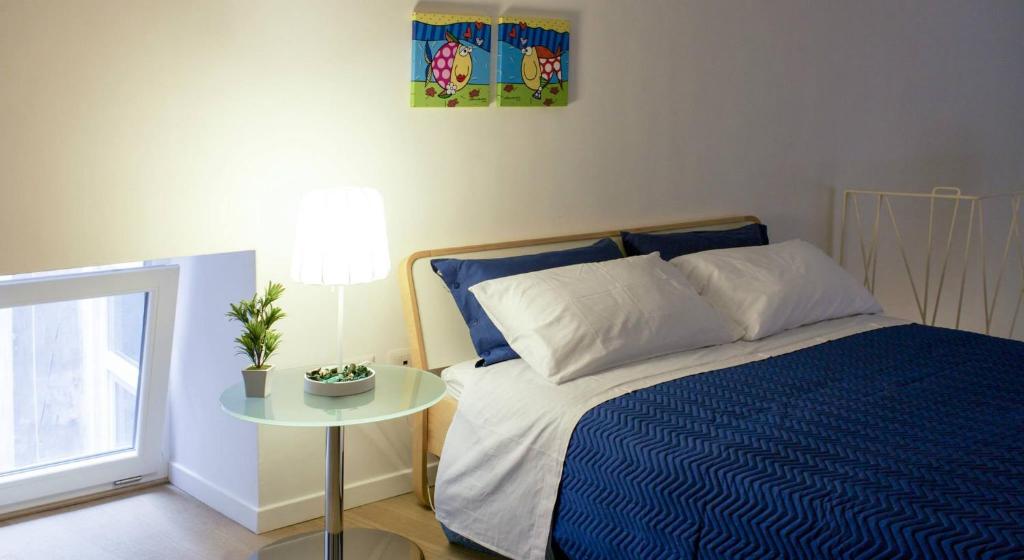 那不勒斯那不勒斯卢尔度假屋的一间卧室配有一张床和一张桌子,上面有植物