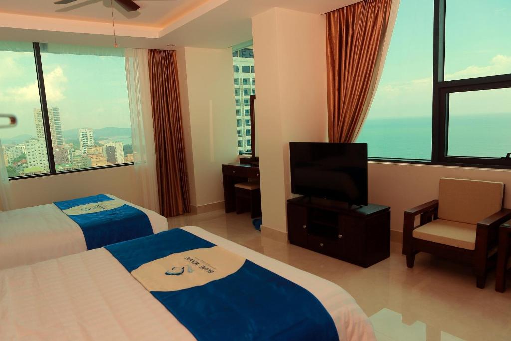 格卢市社Blue Wave Hotel的酒店客房设有两张床和一台平面电视。