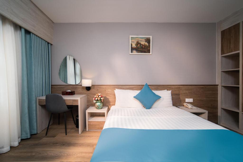 河内首都花园酒店的配有一张床和一张书桌的酒店客房