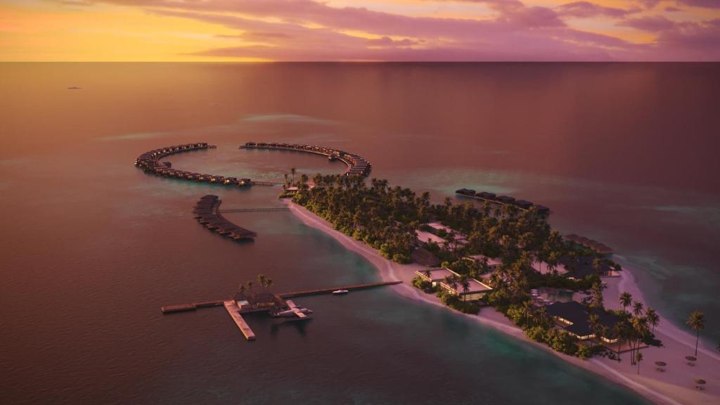 拉斯杜Veligandu Maldives Resort Island的日落时分水中的一个岛屿