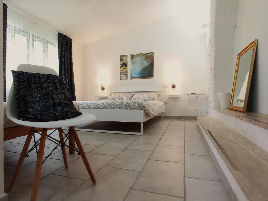 朱尔迪尼亚诺Gli Archi Country Home的一间卧室配有一张床和一把椅子