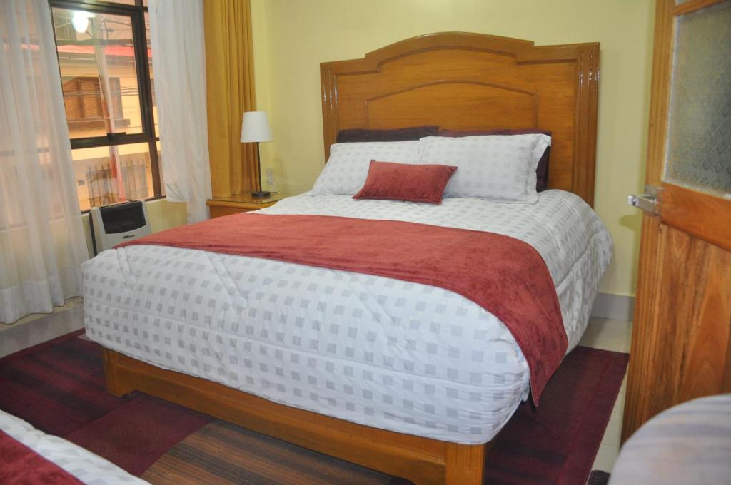 奥鲁罗COMODORO DEPARTAMENTOS的一间卧室配有一张大床,上面有红色枕头
