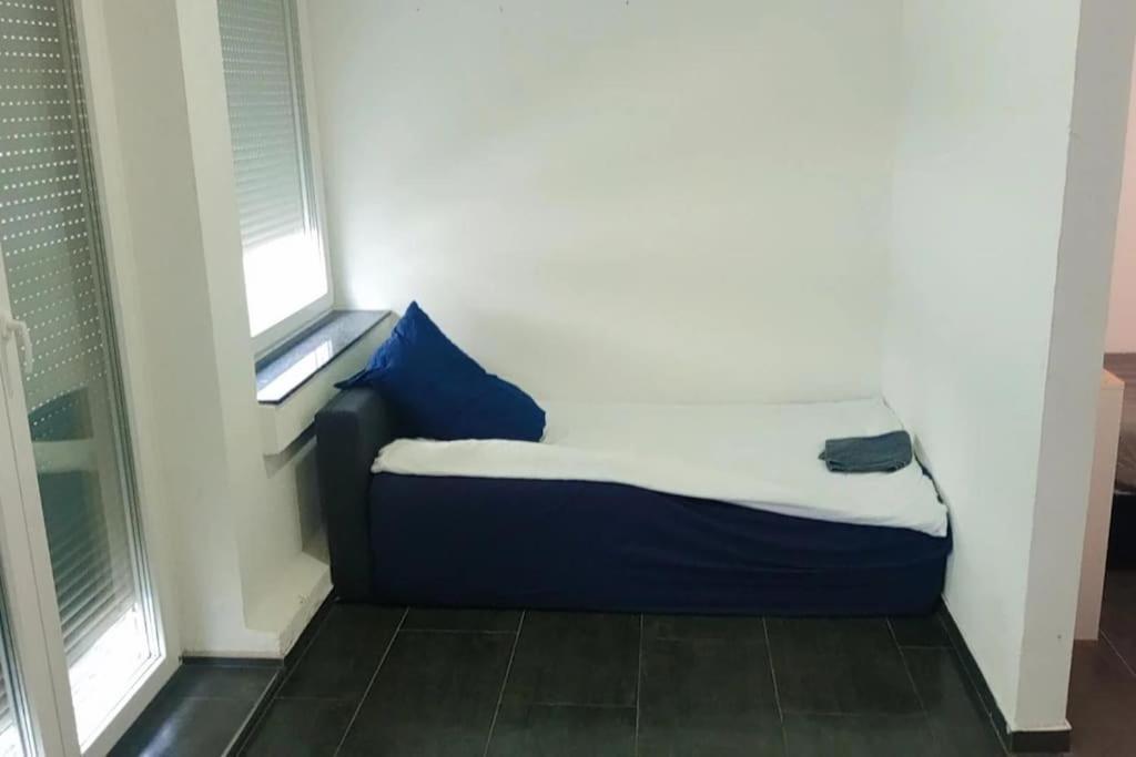 海尔布隆Celine Zimmer in Heilbronn Zentrum的一张小床,位于带两个窗户的房间