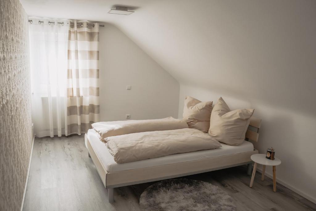 施韦因福特Stilvolles Apartment的卧室内的一张带白色床单和枕头的床
