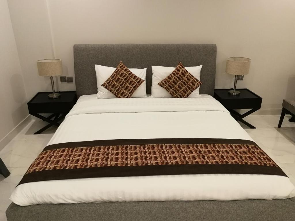 朱菲尔Infinity Juffair Suites的一间卧室配有一张带三个枕头的大床