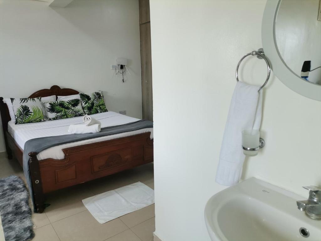 蒙巴萨Millan Homes的浴室设有床、水槽和镜子