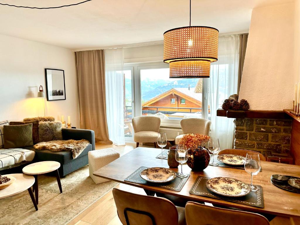 克莱恩 蒙塔纳Window on Crans Montana, Appartement avec vue sur les Alpes的一间带桌子的客厅和一间餐厅
