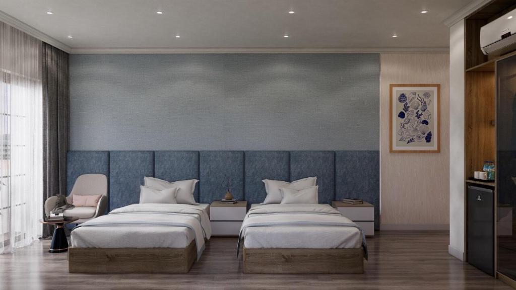 后川Wonderland Villa Hồ Tràm Beach的一间卧室设有两张床和蓝色的墙壁