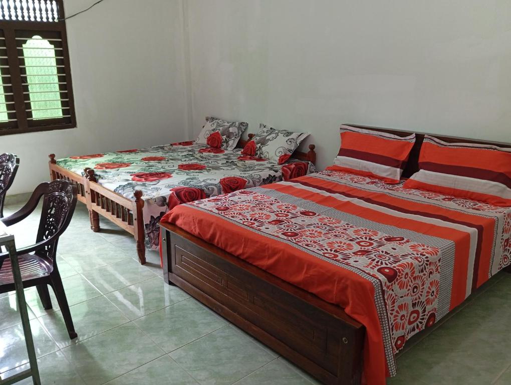 贾夫纳NMA Holiday INN的一间卧室配有两张床和一张桌子及椅子