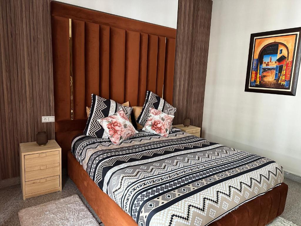 拉巴特Appartement la gare Rabat ville的一间卧室配有一张带木制床头板和枕头的床。