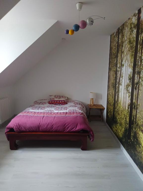 Argentré-du-PlessisLocation chez l habitant的一间卧室配有一张带紫色棉被的床