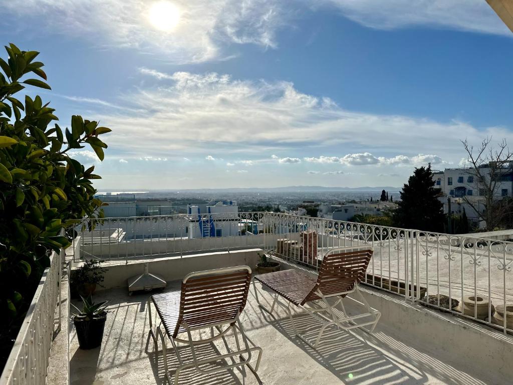 西迪·布·赛义德Tolila Sidi Bou Said, grande terrasse avec vue的两把椅子坐在阳台顶