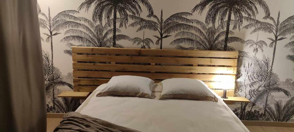 勒唐蓬Les Camélias的卧室配有一张墙上棕榈树床。