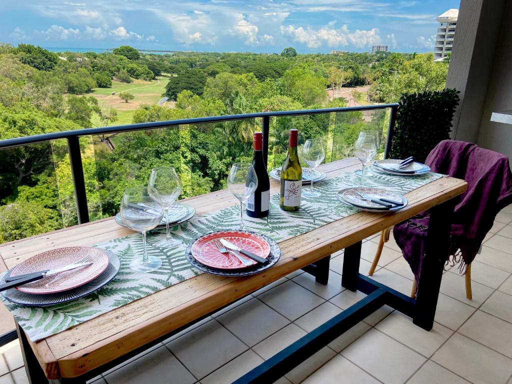 达尔文Beautiful spacious city apartment with views out to the Arafura Sea的阳台上配有带葡萄酒瓶和玻璃杯的桌子