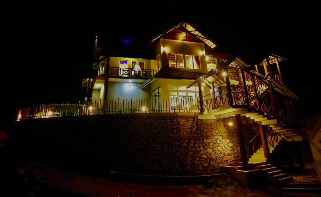 蒙纳The RaaRees Resort - A Hidden Resort in Munnar的一间大房子,晚上有灯