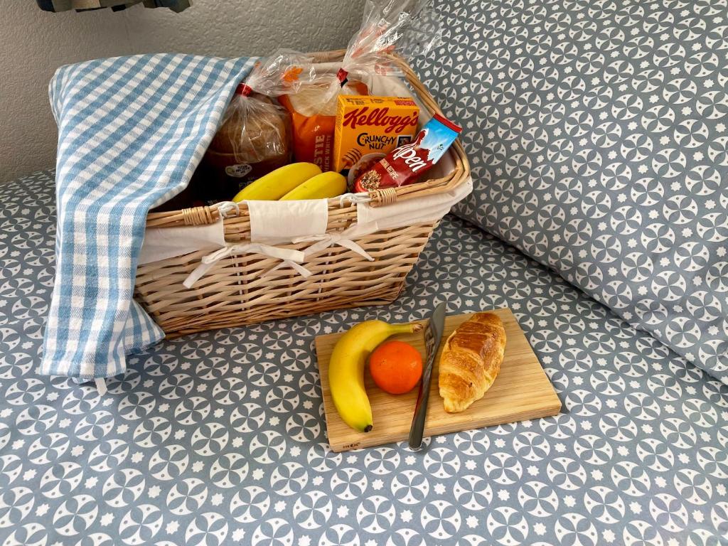 佩恩顿Seaside Homestay - Ensuite twin room with Kitchenette的床上一篮水果和面包