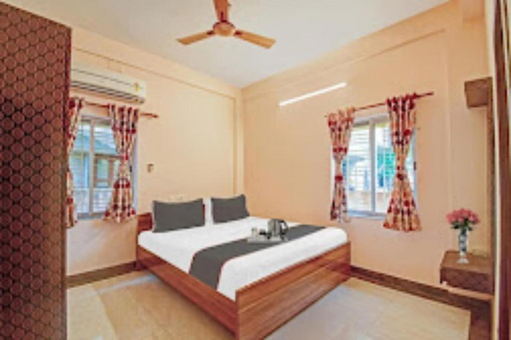 ThākurdwariArhan Villa Inn Kolkata的一间卧室设有一张床和两个窗户。