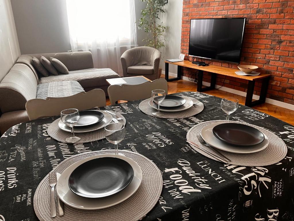 卢布林Zamkowy Apartament的客厅配有带盘子和酒杯的桌子