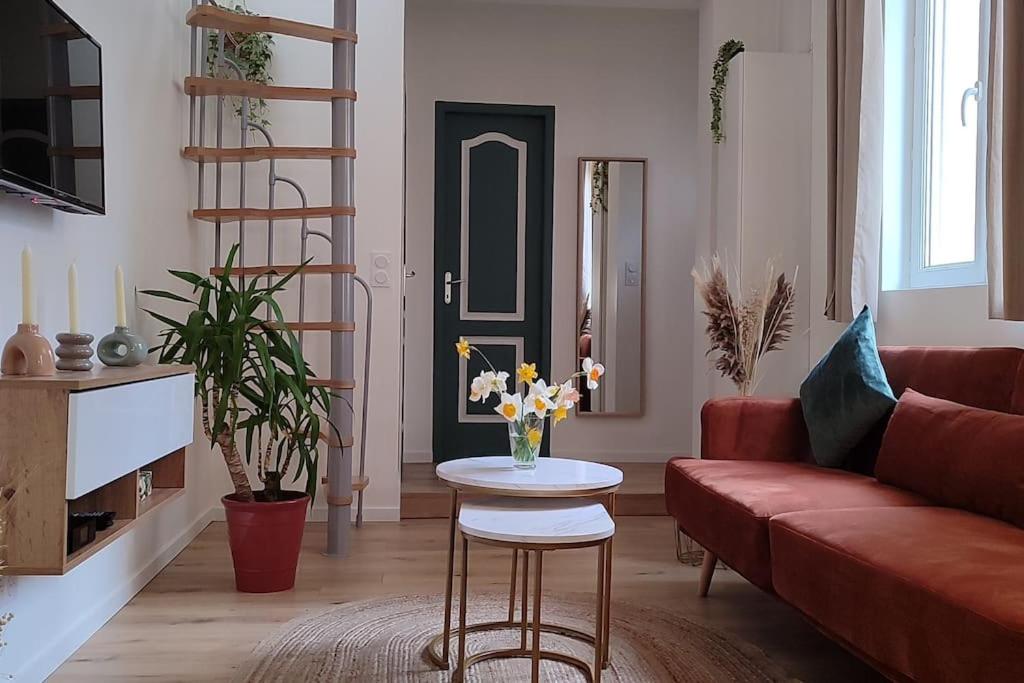 克莱蒙费朗Maison cosy terrasse ensoleillé的客厅配有红色的沙发和带鲜花的桌子