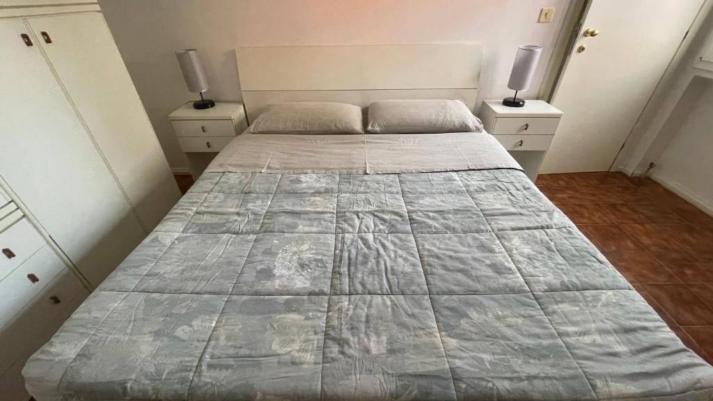 雷诺河畔卡萨莱基奥Bilocale Incantevole的一间卧室配有一张带2个床头柜的大床