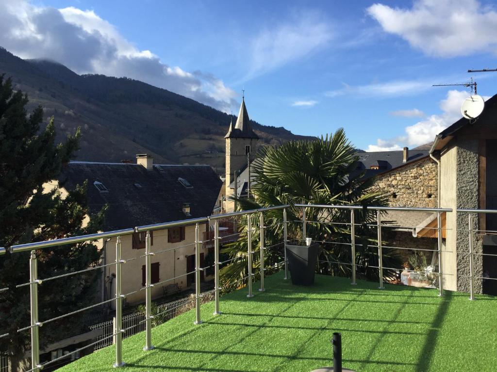 阿斯特Maison au calme vue sur les montagnes的一个带绿草的阳台和一个教堂