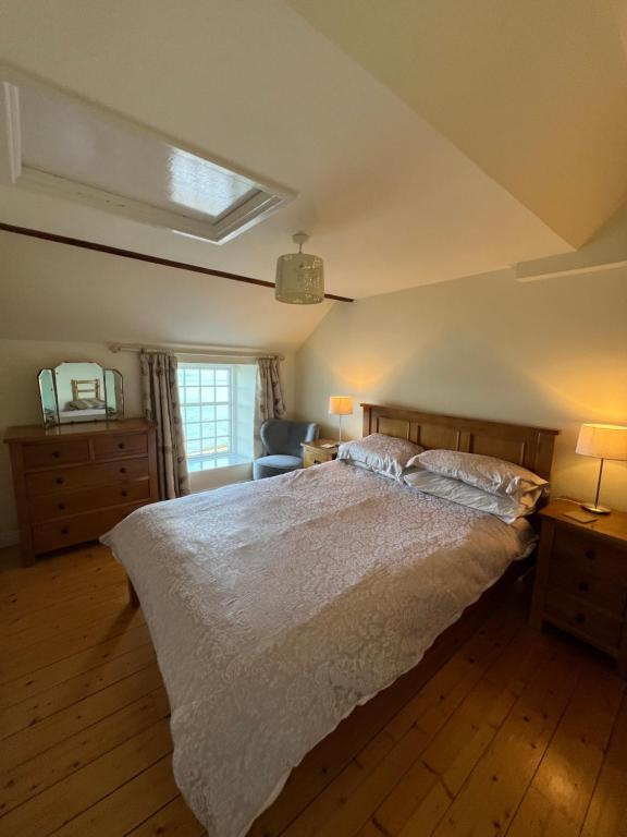 纽卡斯尔Slieve Donard Cottage Widows Row cottages的一间卧室设有一张大床和一个窗户。