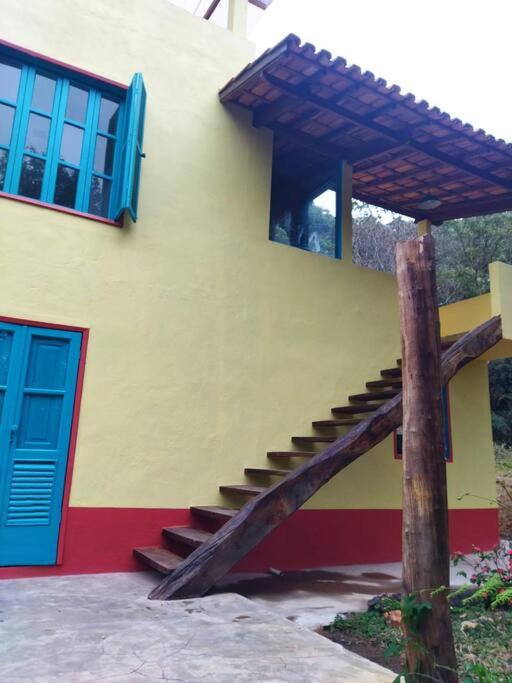阿尤鲁奥卡Casa do Bosque的一座建筑,楼梯靠近蓝色的门