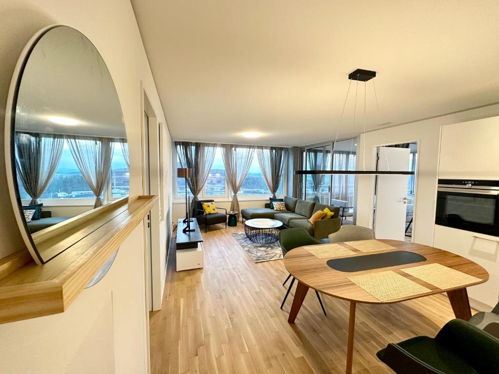 诺伊豪森3.5Room@MydiHei Apartments的开放式的客厅配有桌子和客厅。