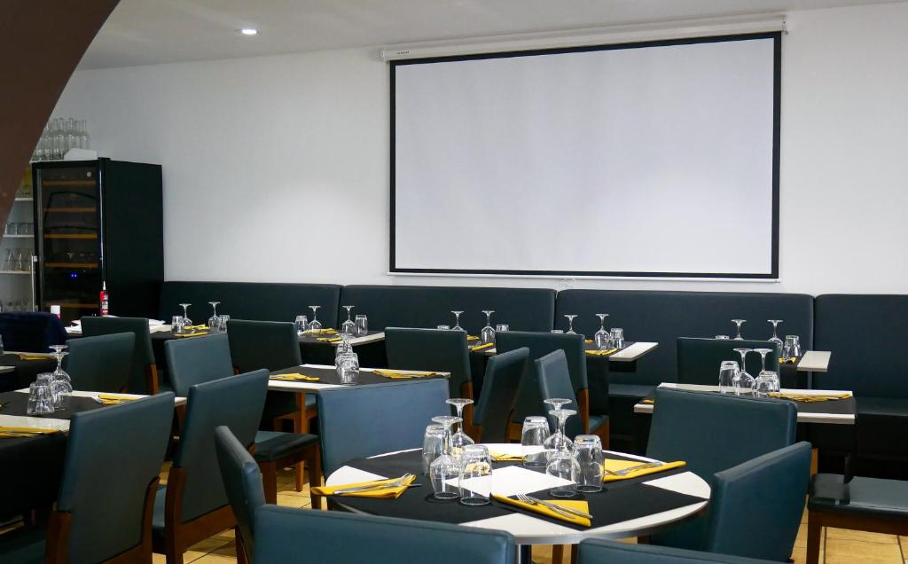 巴拉吕克莱班LE CENTRAL HOTEL BAR RESTAURANT的一间带桌椅和白板的用餐室