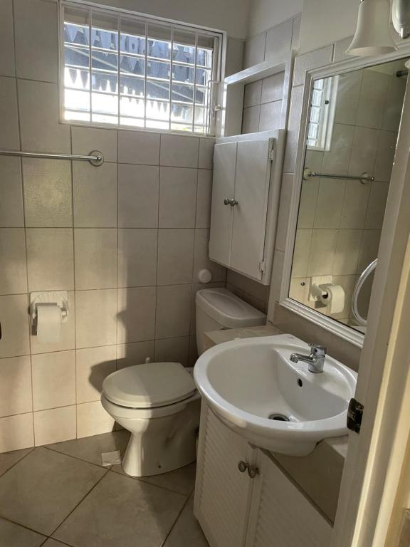 布里奇敦Studio apartment in heart of south coast Barbados的白色的浴室设有卫生间和水槽。