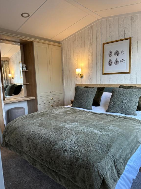 塔特舍尔Luxury Lakeside Lodge, Hot Tub & Private Fishing的一间卧室配有一张带蓝色枕头的大床