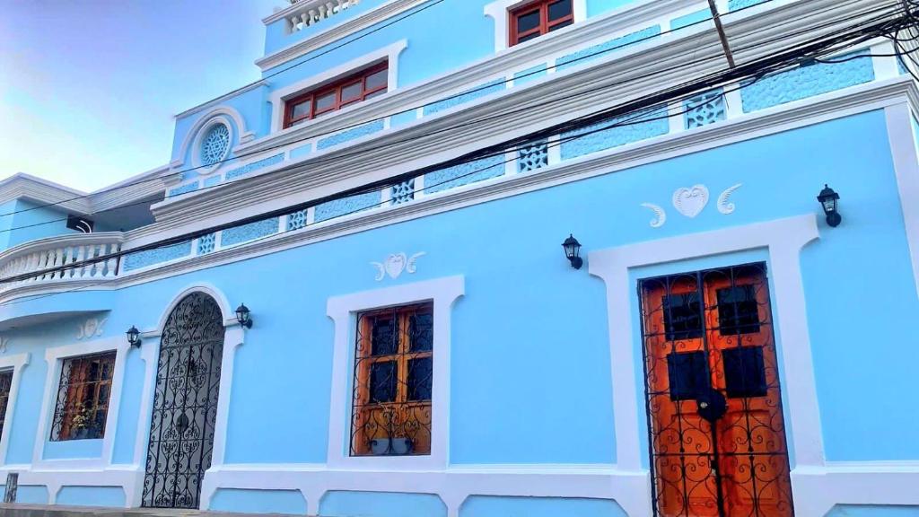 里奥阿查Luna Nueva Casa de Huéspedes的蓝色的建筑,有两个红色的门