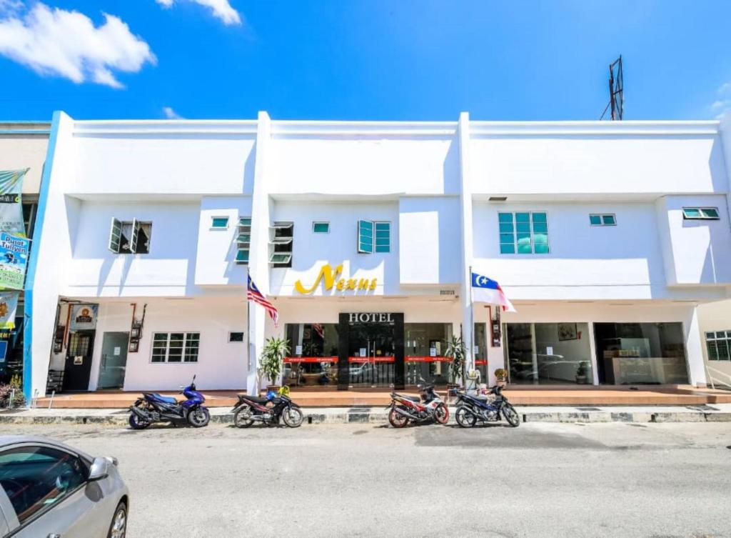 马六甲Nexus Hotel的停在酒店前面的一排摩托车