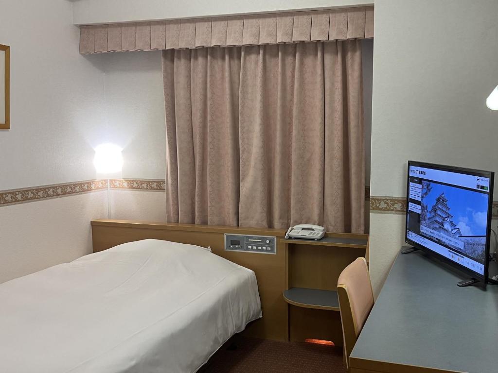 会津若松Hotel Alpha-One Aizuwakamatsu的配有一张床和一台平面电视的酒店客房