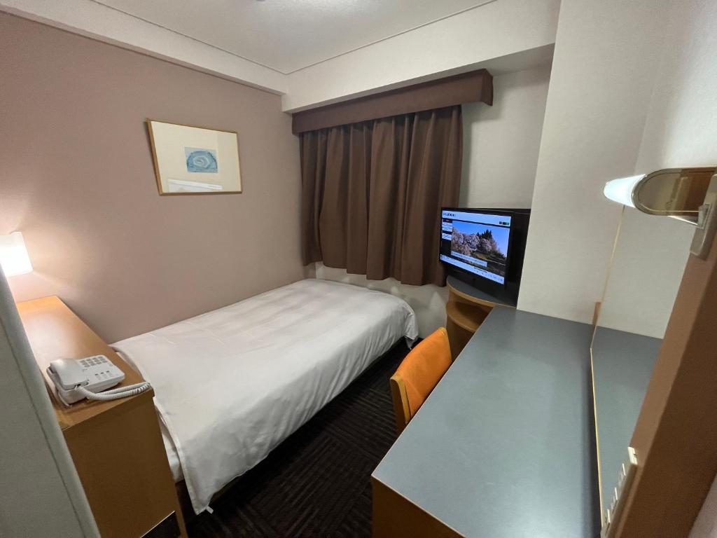 郡山Hotel Alpha-One Koriyama Higashiguchi的配有一张床和一台平面电视的酒店客房