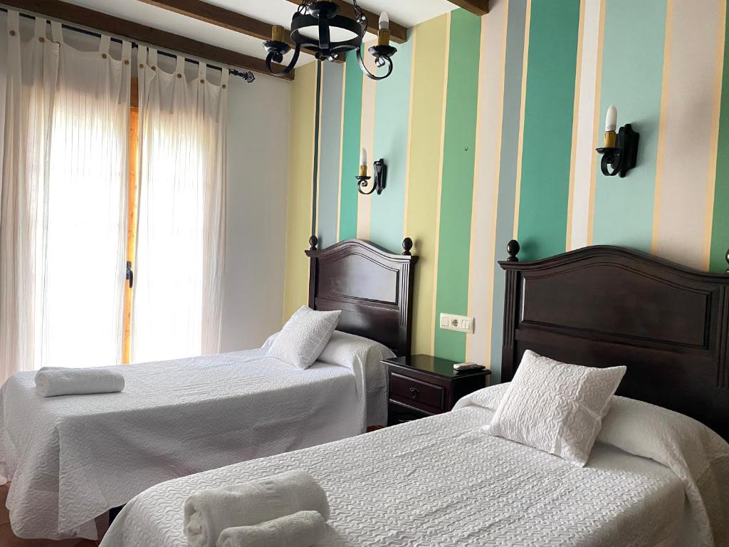 哈兰迪雅·德·拉·维尔Hostal El Descanso Del Emperador的绿白带的客房内的两张床