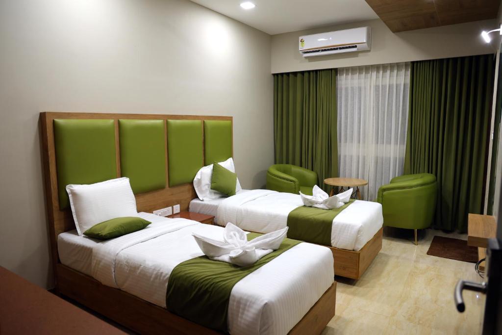 钦奈Miot Grande的绿意盎然的酒店客房内的两张床